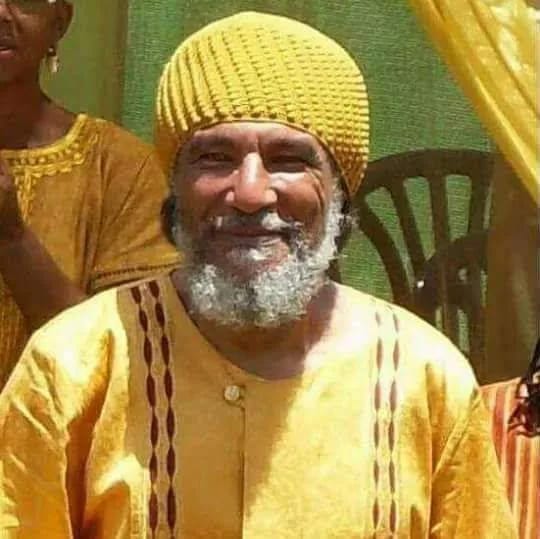 Elder man in yellow at a Village of Peace cultural gathering