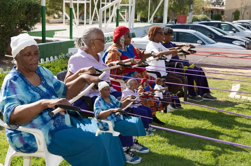 Elders working together at a Village of Peace textile table